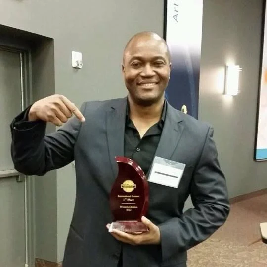 Patrick holding his Toastmasters first-place trophy
