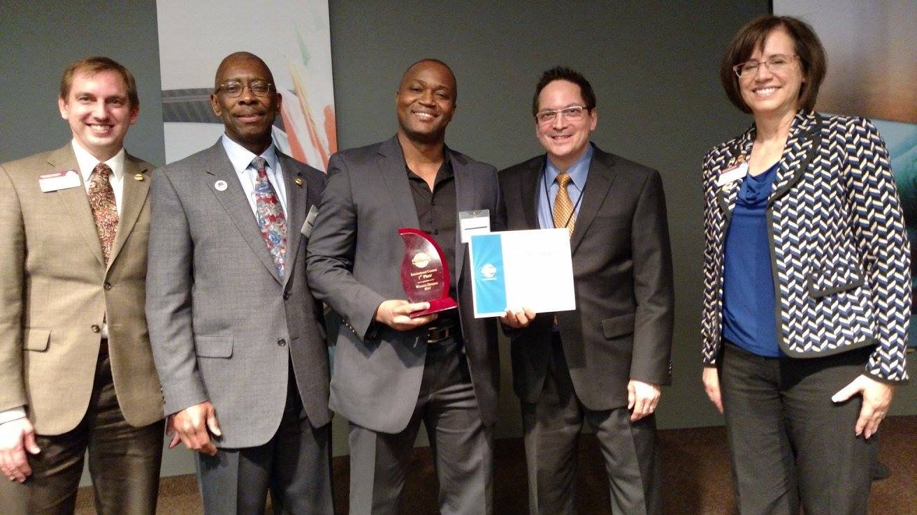 Patrick Meniboon holding a speaking award and certificate with event leaders