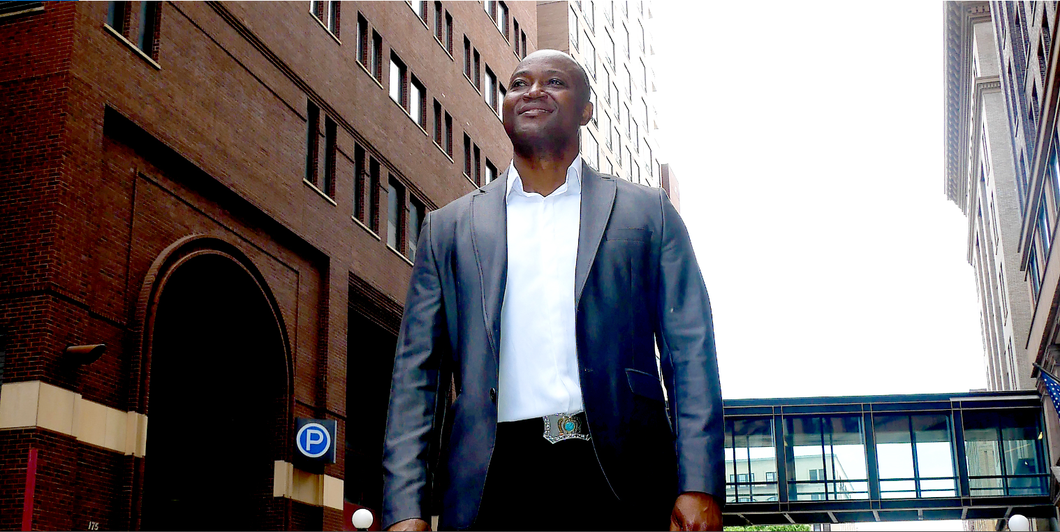 Patrick Meniboon in a gray blazer on a downtown street