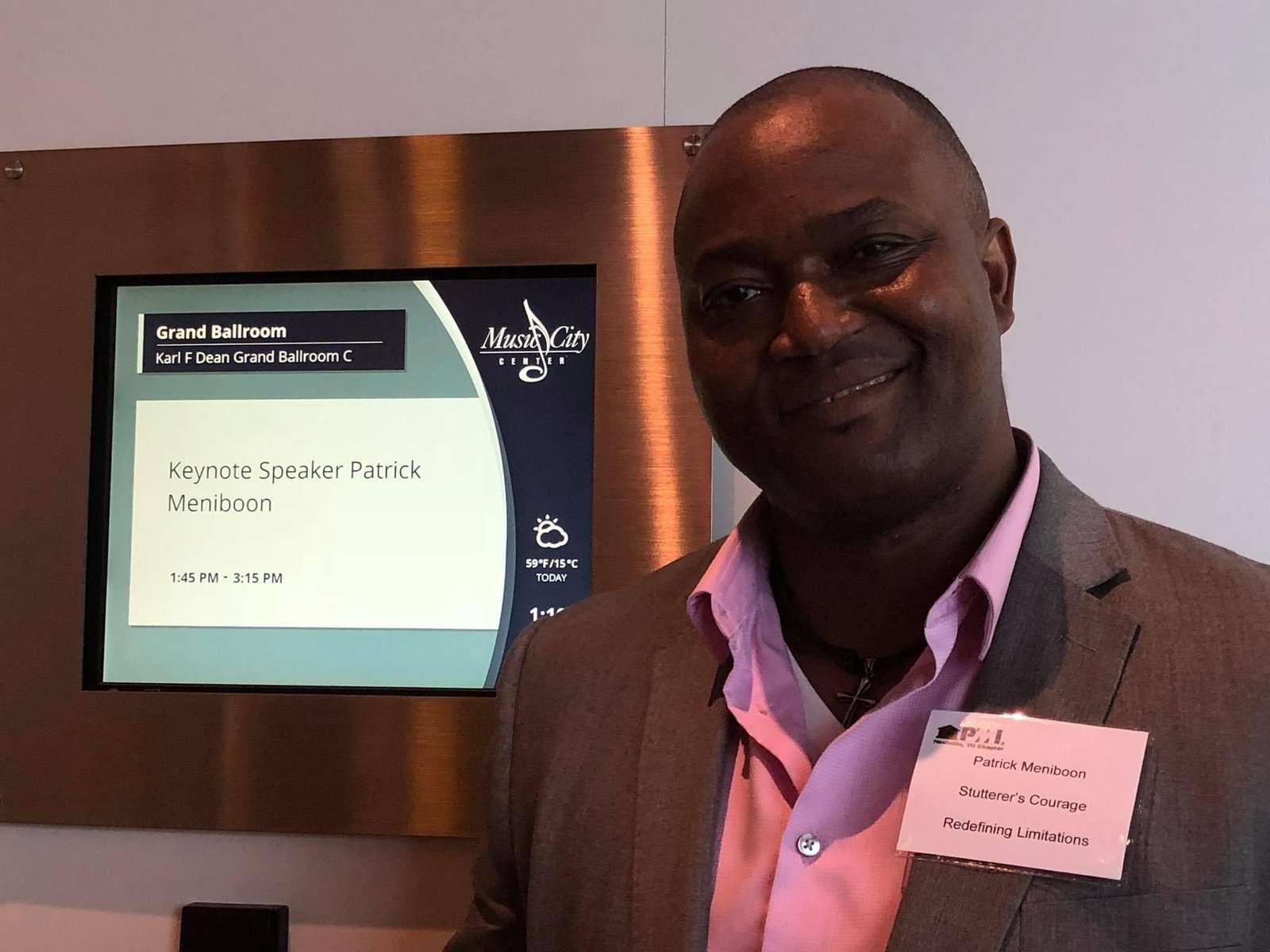 Patrick Meniboon beside a PMI Nashville sign identifying him as the keynote speaker